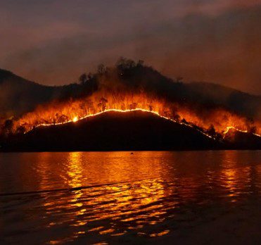 Forest fire behind a lake
